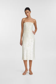 A model wearing the Nico Dress, an ivory sequin midi dress with a strapless corseted bodice and fitted column silhouette.